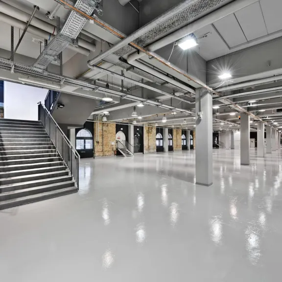 Weitläufiger, moderner Innenraum mit glänzendem Boden und breiter Treppe