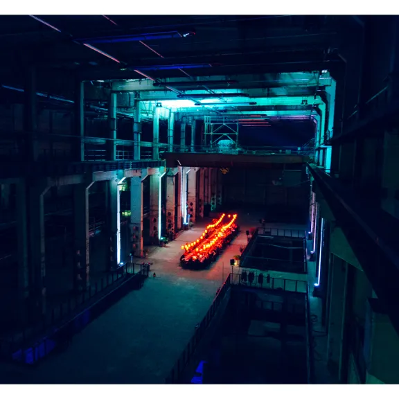 Industrielle Halle mit Neonbeleuchtung und leuchtenden Tischen in der Mitte