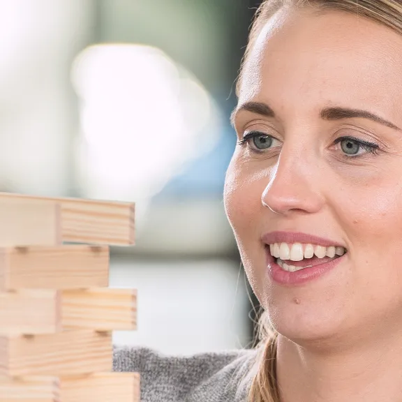 Frau baut mit Kapla Steinen