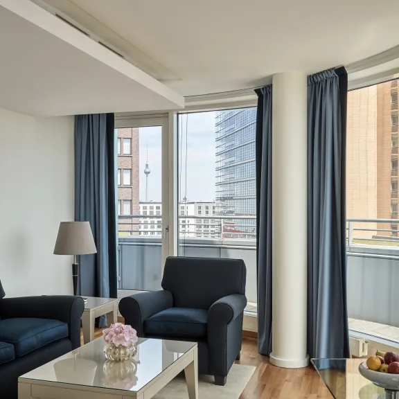 Helles Wohnzimmer mit zwei Sofas, großem Fenster und Blick auf die Stadt