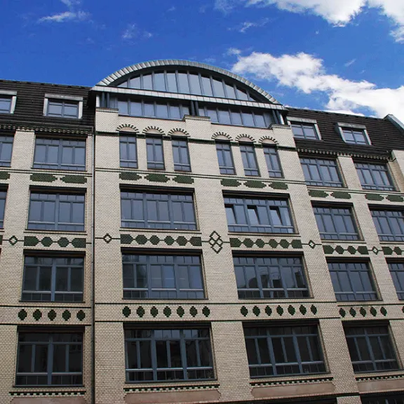 Gekacheltes, 5-stöckiges Gebäude, blauer Himmel mit weißen Wolken