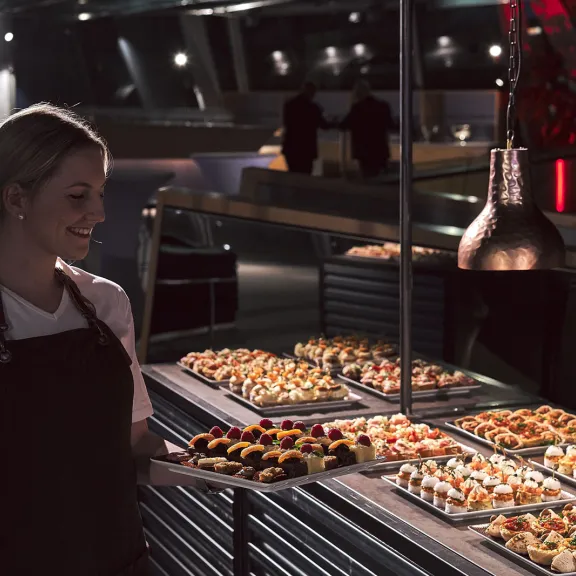 waitress in front of aveato catering buffet