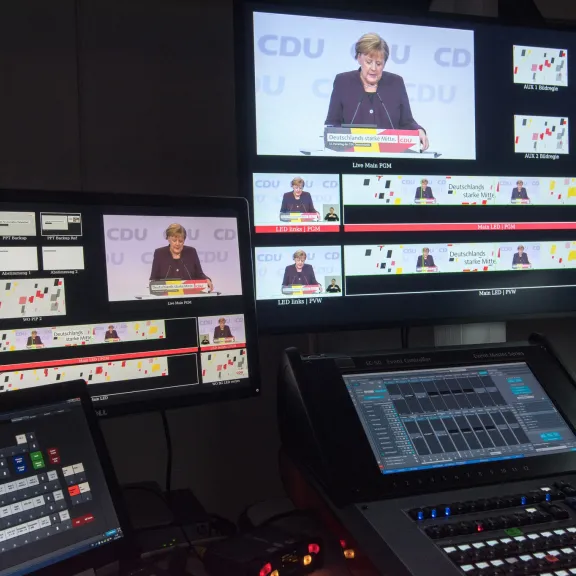 Regieraum mit Monitoren, die eine Frau bei einer CDU-Veranstaltung zeigen
