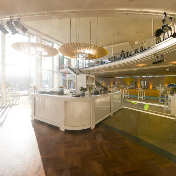 Modernes, sonnendurchflutetes Café mit runden Lampen und weißen Theken.