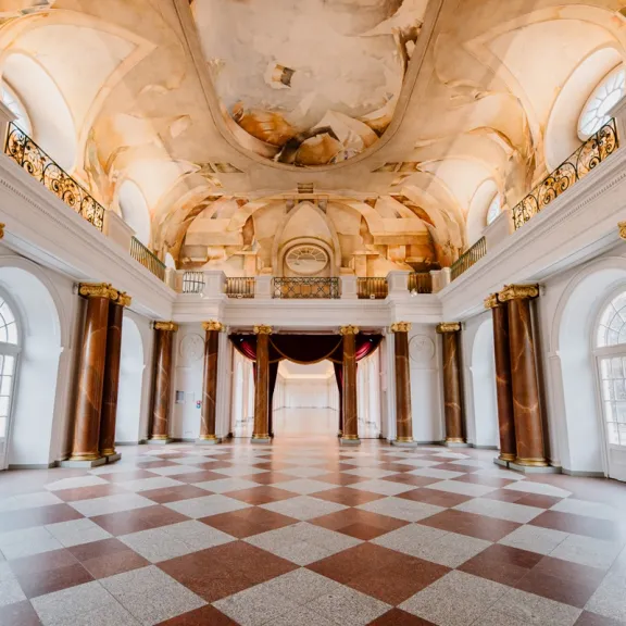 Prunkvoller Saal mit Marmorsäulen, bemalter Decke und großen Fenstern