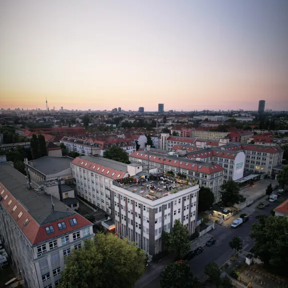 Stadtansicht bei Sonnenuntergang mit roten Dächern und ruhigen Straßen