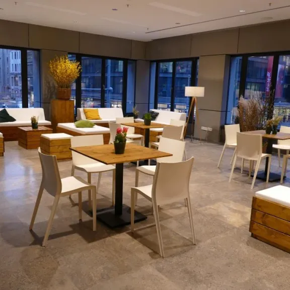 Modernes, gemütliches Café mit Holzmöbeln und großen Fenstern.