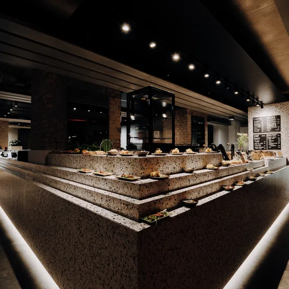 Modernes Restaurant mit Buffet und stimmungsvoller Beleuchtung.