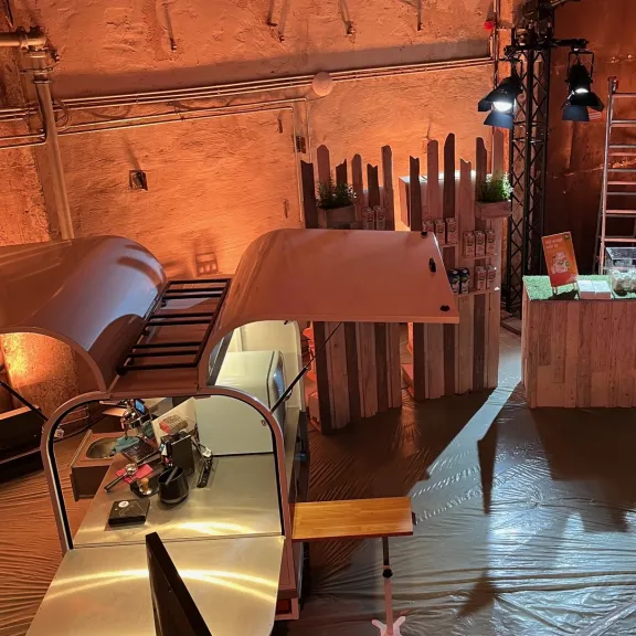 Messestand im rustikalen Stil mit Holzdekor und warmem Licht.