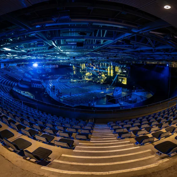 Leeres, blau beleuchtetes Amphitheater mit Blick auf Bühne und Sitzreihen