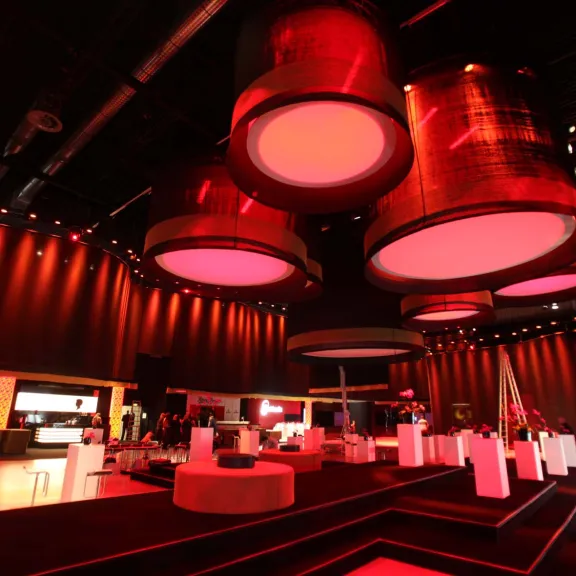 Stylische Lounge mit roter Beleuchtung, modernen Möbeln und großen runden Lampen an der Decke.