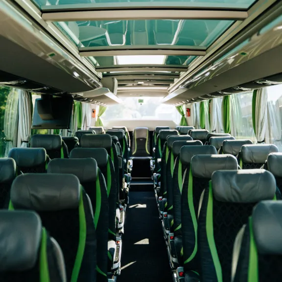 (4)	Bus-Innenraum eines Schröder Busses mit grau-grünen Sitzen.