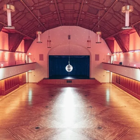 Discokugel im leeren Festsaal mit atmosphärischem Licht