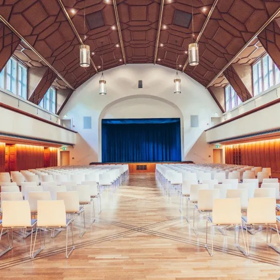 Reihenbestuhlung mit zentriertem Blick auf die Bühne