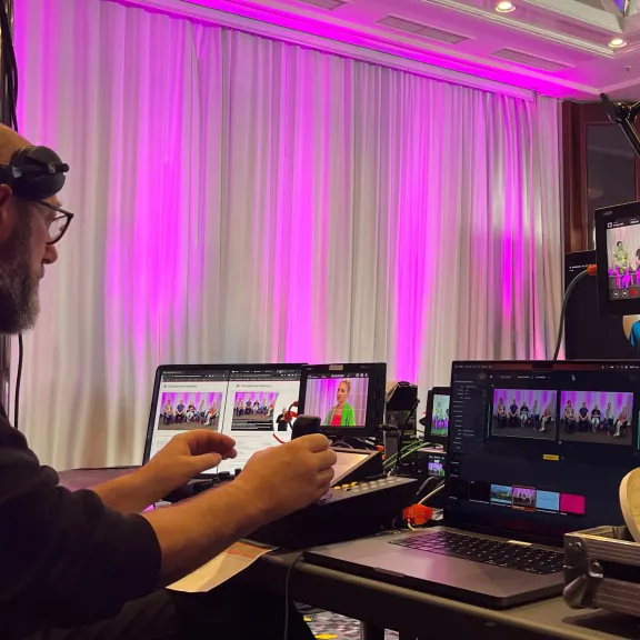 eine Person, die von Streaming-Geräten umgeben ist, steuert eine Kamera.