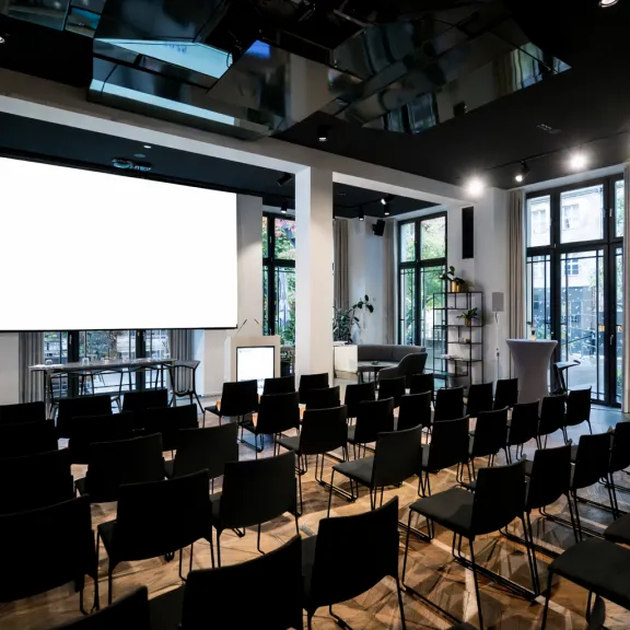 Wintergarten im Data Space Berlin mit Bestuhlung in Reihen für eine Corporate-Veranstaltung.
