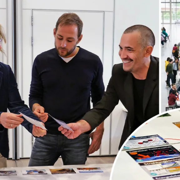 Mehrere Menschen arbeiten und diskutieren gemeinsam an Projekten in einem offenen Raum.