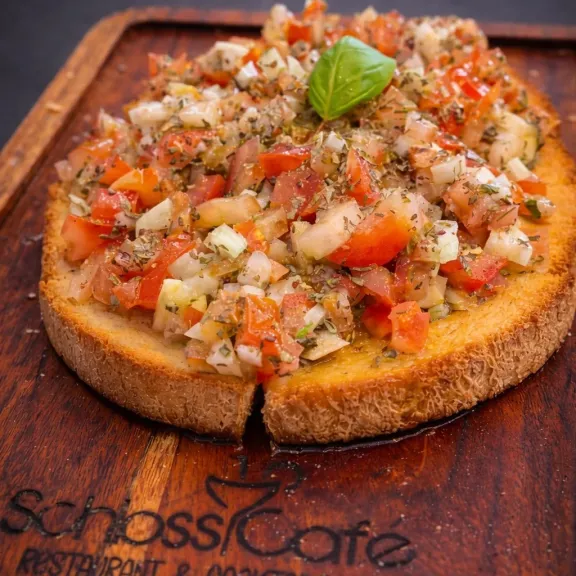 Frisch zubereitete Bruschetta mit Tomaten und Basilikum aus dem Schloss Café Berlin-Charlottenburg – italienisch-mediterrane Küche und Catering.