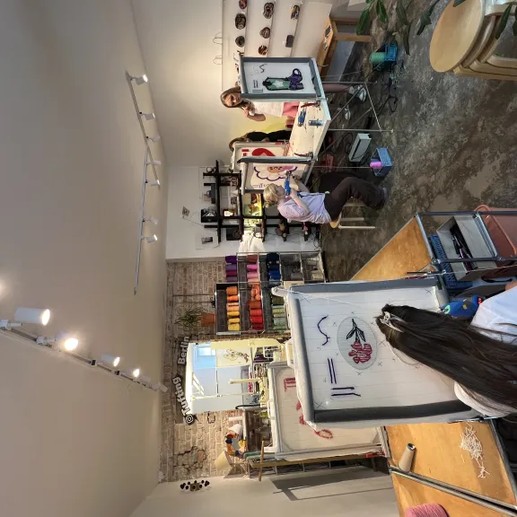 Künstleratelier mit mehreren Menschen, die an Staffeleien malen.
