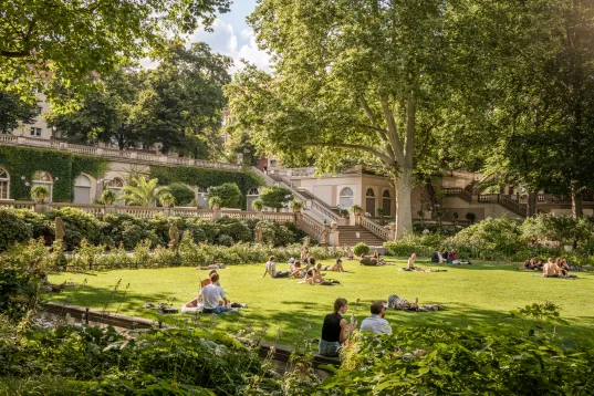 Körnerpark in Berlin Neukölln, people sitting on the grass and having a picnic