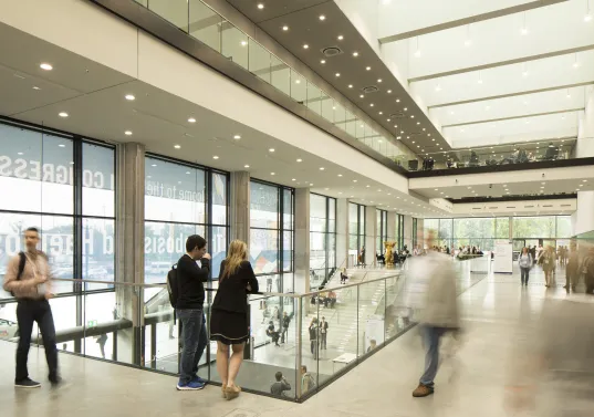 Helle, moderne Eingangshalle mit mehreren Menschen in Bewegung.