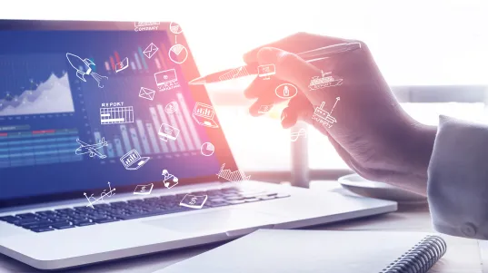 Digitale Analyse: Hand interagiert mit virtuellen Symbolen über Laptop mit Diagrammen und Daten.