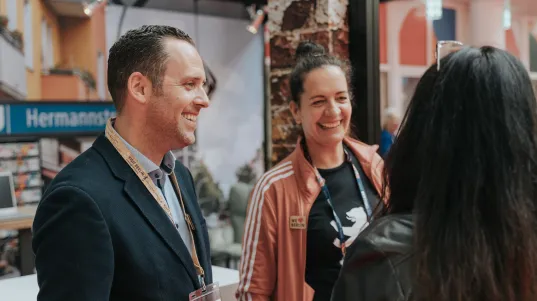 Employees of the visitBerlin Berlin Convention Office talking to partners at a trade fair