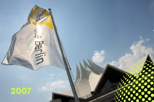 Weiße Fahne vor dem Tempodrom Berlin unter blauem Himmel, gelbe Jahreszahl 2007.