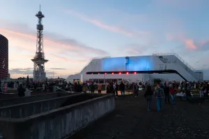 Evening atmosphere with the illuminated Funkturm and visitors on the grounds of the 49th ICC Berlin