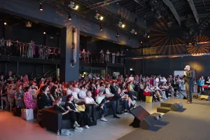 An audience listens to a speaker