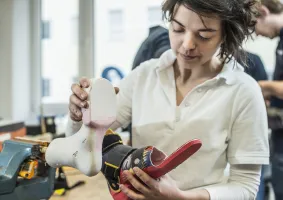 Technician examines orthopedic insole in workshop.