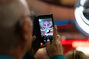 A man photographing a colourful light installation in the ICC Berlin with his smartphone.