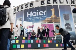 People posing on a colorful stage outside Messe Berlin exhibition center.
