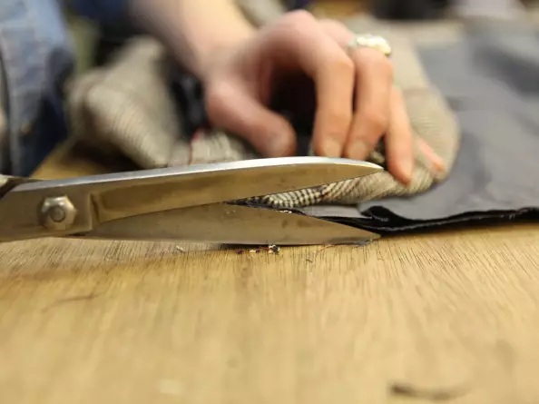 Schneiderin schneidert maßgerechte Kleidung mithilfe einer Schere