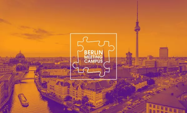 Panoramic view of Berlin featuring the Berlin Cathedral, the Spree River, and the TV Tower. The image is overlaid with an orange-purple color filter. Centered in the foreground is the “Berlin Meeting Campus” logo in the shape of a puzzle piece.