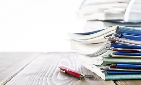 Stacked files with a ballpoint pen.