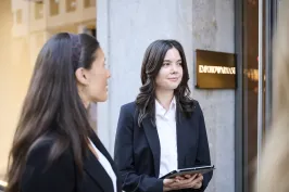 Zwei Frauen in schwarzen Blazern stehen vor einem Laden, eine hält ein Tablet – Eventpersonal und Promotionteam im Einsatz.
