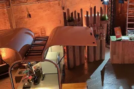 Messestand im rustikalen Stil mit Holzdekor und warmem Licht.