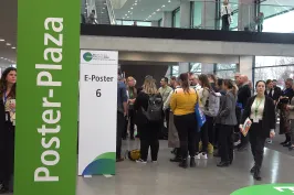 Teilnehmende versammeln sich auf dem DKK 2024 in der Poster-Plaza vor einer ePoster-Station, um wissenschaftliche Beiträge zu diskutieren.