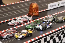 Sechs Modellrennautos stehen an der Startlinie einer Slotcar-Bahn.