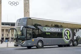 (1)	Moderner grauer Doppeldecker-Reisebus mit der Aufschrift „Schröder Reisen“ steht vor dem Berliner Olympiastadion; im Hintergrund sind die beiden Türme mit den Olympischen Ringen zu sehen.