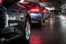 Mehrere Autos stehen hintereinander in einer beleuchteten Tiefgarage.