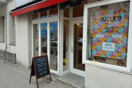 Café-Eingang mit bunter Fensterdekoration und Tafel vor der Tür.