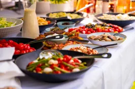 Verschiedene bunte Vorspeisen auf einem Buffet mit Salaten und Gemüse.
