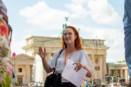 Reiseführerin Natalie leitet eine kleine Gruppe vor dem Brandenburger Tor, Berlin.