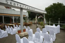 Terrasse der Tegeler Seeterrassen am Tegeler See mit Rosenbogen und festlich eingedeckter Hochzeitstafel