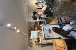 Künstleratelier mit mehreren Menschen, die an Staffeleien malen.