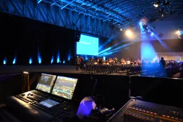 Ton- und Lichttechnikpult bei einer beleuchteten Bühnenshow in großer Halle