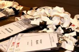 Namensschilder mit weißen Schlüsselbändern liegen auf einem Tisch.