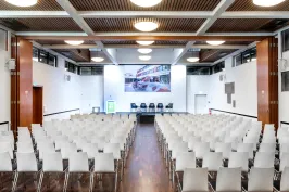 Leerer Konferenzraum mit weißen Stühlen und Podium vorne